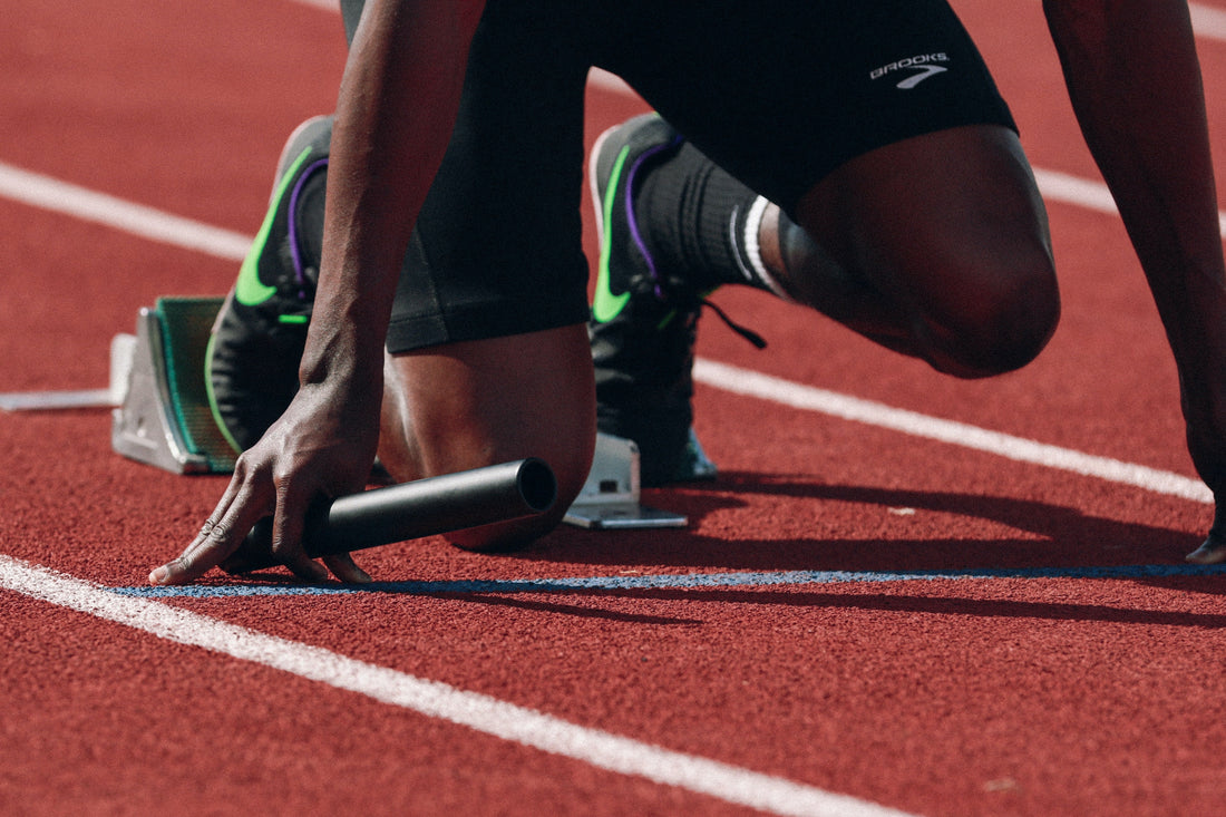 runner on track with baton ready to start