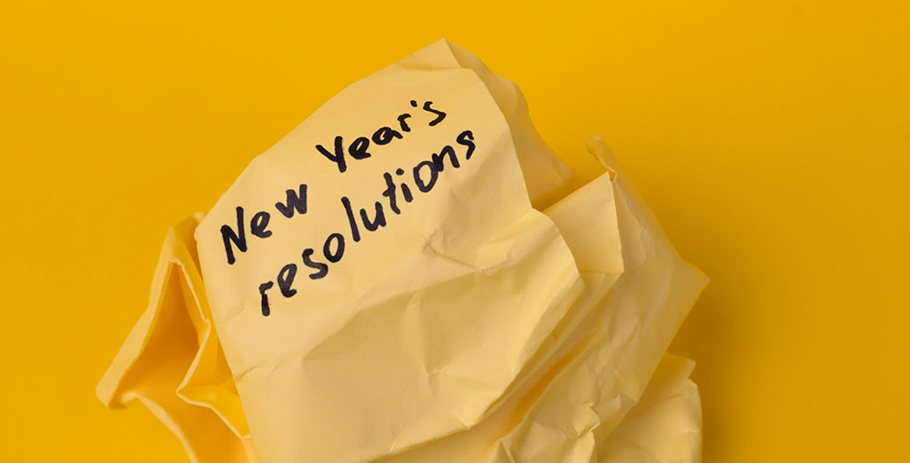 crumpled up paper with new years resolutions written on it